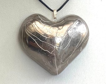 Large silver heart pendant with an adjustable leather thong.