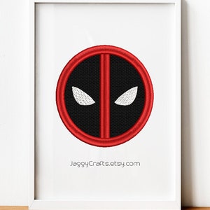 May include: Framed artwork featuring the Deadpool logo. The design is a black circle with a red border and a vertical red line through the center. Two white eye shapes are present. The Etsy shop name, JaggyCrafts.etsy.com, is printed at the bottom.