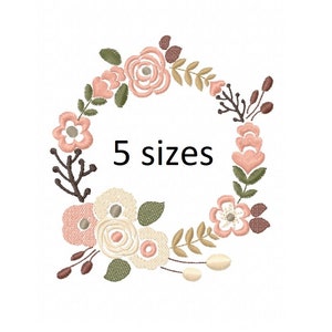 Peut inclure: Un motif de broderie de couronne florale avec des fleurs roses, blanches et brunes. Le motif comprend des feuilles et des branches. Le texte "5 tailles" est au centre de la couronne.