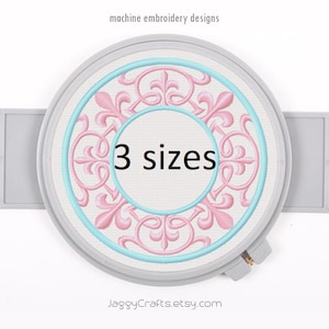May include: A white embroidery hoop with a pink and blue floral design. The text "3 sizes" is in the center of the design. The text "JaggyCrafts.etsy.com" is at the bottom of the hoop.