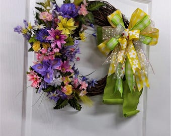 Spring grapevine wreath with bright colored flowers for your home decoration