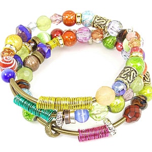May include: Multi-colored beaded bracelet with a gold wire wrap. The bracelet features a variety of beads, including green, red, blue, and purple.