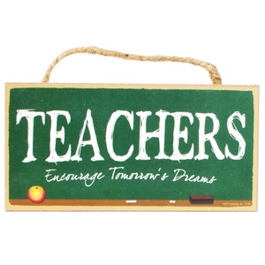 May include: A green chalkboard sign with the text "TEACHERS Encourage Tomorrow's Dreams". The sign has a red apple and a white chalk eraser on it.