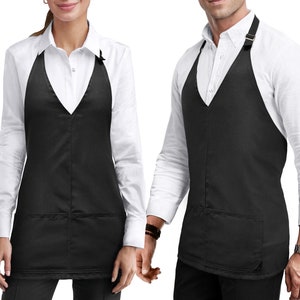 May include: Black V-neck apron with a single pocket. The apron has adjustable straps and a V-neckline.