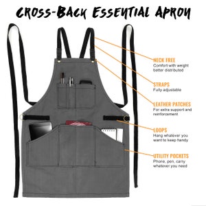 May include: Gray canvas apron with adjustable straps, leather patches, and multiple pockets. The apron has a cross-back design and features loops for hanging items.