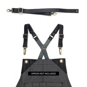 May include: Black leather suspenders with brass hardware and adjustable straps. The suspenders are designed to be worn with an apron, but the apron is not included. "Apron not included" is printed on the fabric.