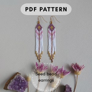 May include: Two beaded earrings with a white, pink, gold, and purple design. The earrings are long and dangle, with a teardrop shape. The image also includes the text "PDF PATTERN" and "Seed bead earrings".