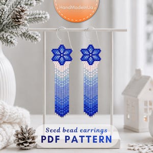 May include: A pair of long, dangling seed bead earrings featuring a six-pointed star design at the top. The beads transition in a gradient from white to light blue and dark blue. The text "Seed bead earrings PDF PATTERN" is visible below.