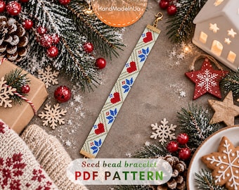 May include: A seed bead bracelet featuring a repeating pattern of red hearts and blue snowflakes on a light background. The bracelet has a gold-toned metal clasp at one end and a gold-toned metal end bar at the other, showcasing a festive design.
