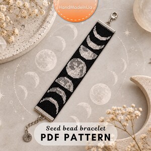 May include: A wide seed bead bracelet featuring a black background with a repeating lunar cycle pattern in shades of gray and white. The bracelet includes silver-toned metal end caps, a lobster claw clasp, and a short extender chain with a star charm.
