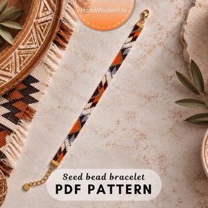 Op de afbeelding: Een armband van kraaltjes met een geometrisch patroon in tinten oranje, bruin, wit en grijs. De armband is voorzien van een goudkleurige metalen sluiting en een verstelbare kettingverlenging. De tekst "Seed bead bracelet PDF PATTERN" is zichtbaar.