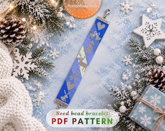 May include: A blue seed bead bracelet featuring a repeating pattern of hearts, bells, and a reindeer in light beige and brown tones. The bracelet is finished with silver-toned metal end caps and a lobster claw clasp, showcasing a detailed design.