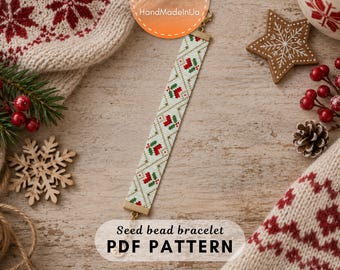 May include: A seed bead bracelet featuring a white background with a repeating diamond grid pattern in gold, accented by small red and green floral motifs. The bracelet has gold-toned metal end bars and a lobster clasp closure with an extender chain.