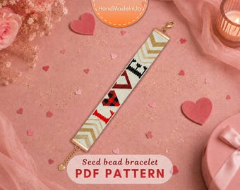 May include: A seed bead bracelet featuring a white background with the word LOVE spelled out in black, red, and red-and-black plaid patterns. The ends of the bracelet are finished with gold-tone metal clasps and a gold-tone chain extender with a heart charm.