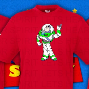 May include: Red t-shirts featuring various Toy Story character designs. One shirt displays the Pizza Planet logo, another Buzz Lightyear, and a third, Jessie. Additional character logos are shown below, including Woody and Mr. Potato Head.