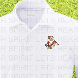May include: White polo shirt with a small cartoon golfer graphic. The shirt is on a green golf course with a golf ball and hole in the background. The text "FOR SPIRIT LETS HEAR IT" is repeated on the shirt.