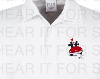 May include: White polo shirt with a red car and two cartoon figures on the left chest. The car has a red heart above it. The text "TEAM" is on a small tag on the shirt.