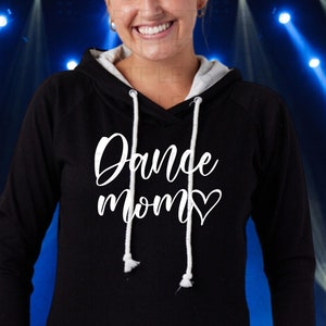 Puede incluir: Sudadera con capucha negra con un gr&aacute;fico blanco que dice "Dance Mom" con un coraz&oacute;n.