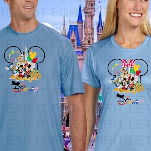 May include: Light blue Dri-FIT performance tees featuring a colorful Disney graphic. The graphic includes Mickey Mouse, Minnie Mouse, and other Disney characters. The text at the bottom reads "Disney". The bottom of the image reads "SHOWN ON DRI-FIT PERFORMANCE TEES LIGHT BLUE NOT AVAILABLE IN PERFORMANCE TANKS- SEE CHARTS".