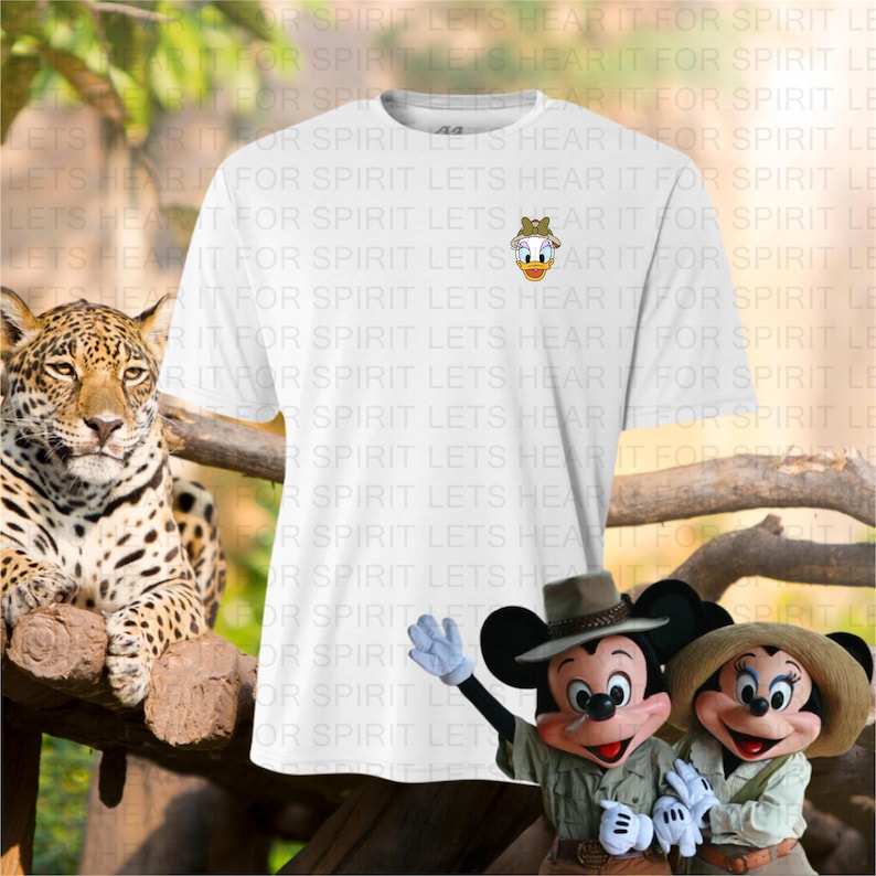 May include: White t-shirt featuring a small embroidered image of Daisy Duck. The shirt is displayed with a jaguar and costumed Mickey and Minnie Mouse characters. The background includes text that reads "FOR SPIRIT LETS HEAR IT FOR SPIRIT LE".