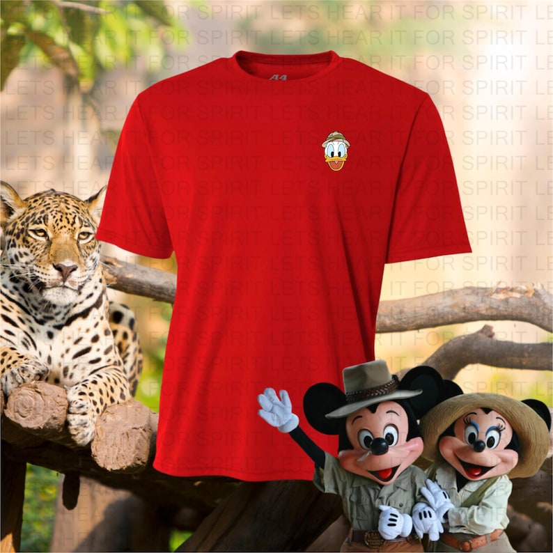 May include: A red t-shirt with a small Donald Duck graphic on the chest. The image also features a jaguar, Mickey Mouse, and Minnie Mouse in safari outfits, suggesting a theme of adventure or travel.