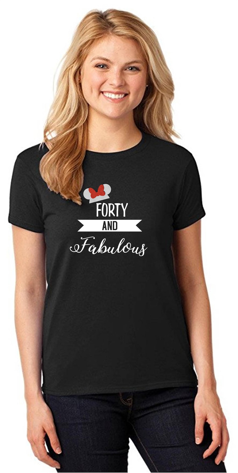 Pode incluir: Camiseta preta com um gr&aacute;fico branco que diz "Forty and Fabulous" com um design de orelha de Mickey Mouse vermelho e branco sobre o texto.