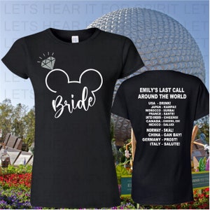 May include: Two black t-shirts with white text. The front shirt has a white Mickey Mouse ear silhouette with a diamond above it and the word "Bride". The back shirt has the text "Emily's Last Call Around the World" and a list of countries and their respective cheers.