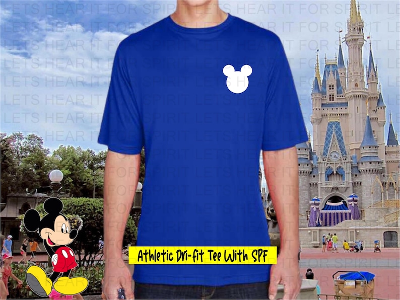 May include: Royal blue athletic Dri-fit tee shirt with a white Mickey Mouse head graphic. The shirt has the text "Athletic Dri-fit Tee With SPF" in yellow. The shirt is short-sleeved and appears to be made of a moisture-wicking material.