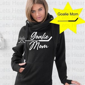 K&ouml;nnte beinhalten: Schwarzer Kapuzenpullover mit einem wei&szlig;en Aufdruck, der "Goalie Mom" mit einem Hockeyschl&auml;ger-Design sagt.