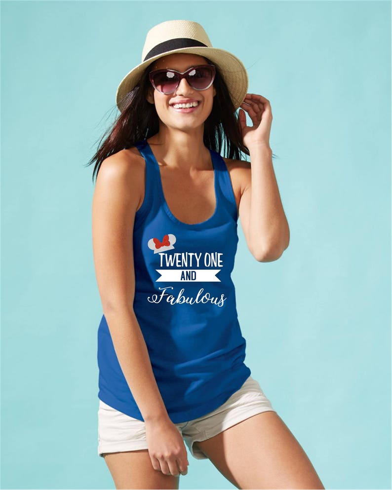 Pode incluir: Um top azul de al&ccedil;as com um gr&aacute;fico branco que diz "Twenty One and Fabulous" com um design de orelhas de Mickey Mouse vermelho e branco sobre o texto.