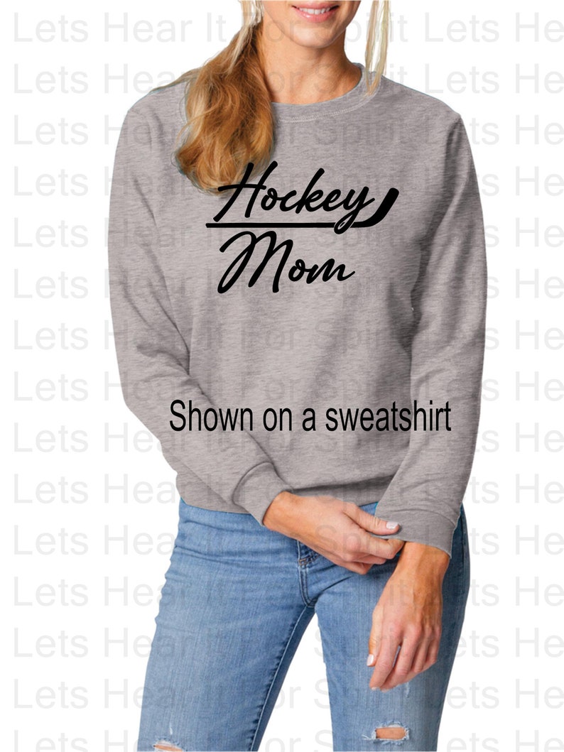 K&ouml;nnte beinhalten: Ein graues Sweatshirt mit dem Text "Hockey Mom" in schwarzen Buchstaben. Der Text ist mit einem Hockeyschl&auml;ger durch das Wort "Mom" stilisiert.