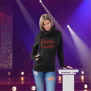 May include: Black hooded sweatshirt with a cowl neck and thumb holes. The sweatshirt has a red glitter design that says "Dance Mom" with a heart.