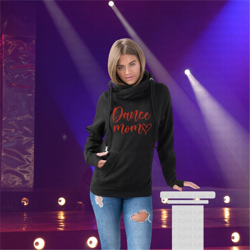 May include: Black hooded sweatshirt with a cowl neck and thumb holes. The sweatshirt has a red glitter design that says "Dance Mom" with a heart.
