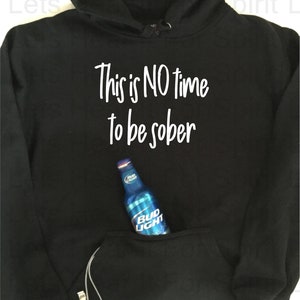 May include: Black hooded sweatshirt with a white graphic that says "This is NO time to be sober" and a blue Bud Light beer bottle in the pocket.