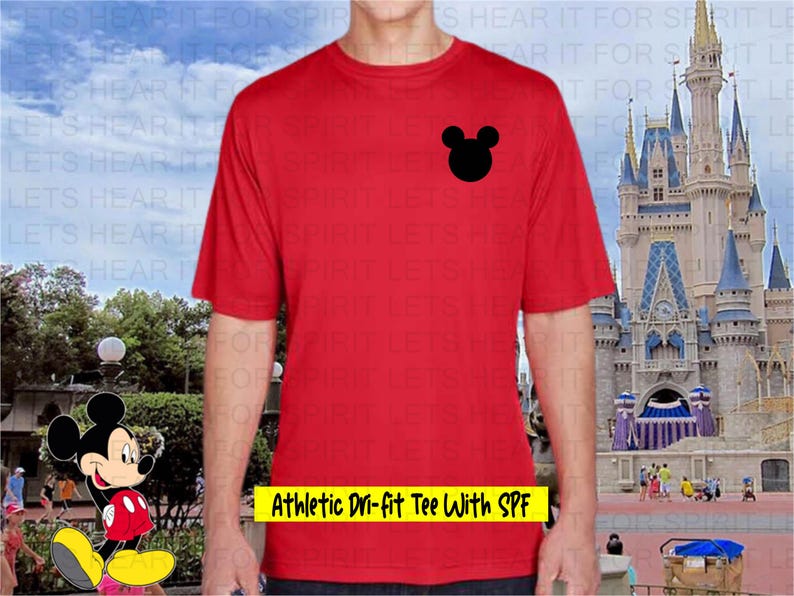 May include: Red athletic dri-fit tee shirt with a black Mickey Mouse head logo. The shirt has the text "Athletic Dri-fit Tee With SPF" in yellow. The shirt is short-sleeved.