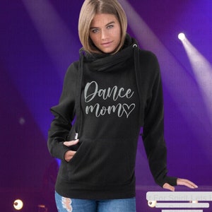 May include: Black hooded sweatshirt with a cowl neck and a silver glitter design that says "Dance mom" with a heart.