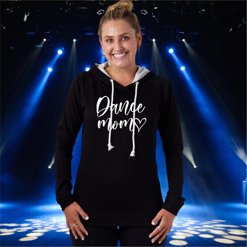 Puede incluir: Sudadera con capucha negra con un gr&aacute;fico blanco que dice "Dance Mom" con un coraz&oacute;n.