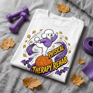 Könnte beinhalten: Ein weißes T-Shirt mit einer Grafik eines weißen Pudels in einem violetten Kapuzenpullover, der auf einem orangefarbenen Kürbis balanciert. Das Design zeigt gelbe Herbstblätter, violette Bänder und kleine violette Fledermaussymbole.