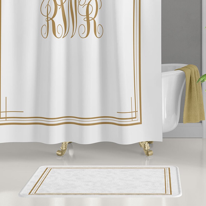 May include: White bath mat with a gold border. The mat has a soft, plush texture.