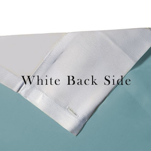 May include: Close-up of a fabric with a white back side and a light blue front side. The text "White Back Side" is printed on the white side.