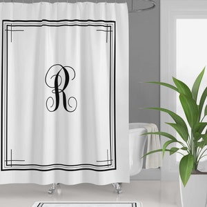 May include: White shower curtain with a black border and a black monogram of the letter "R" in a decorative script font.
