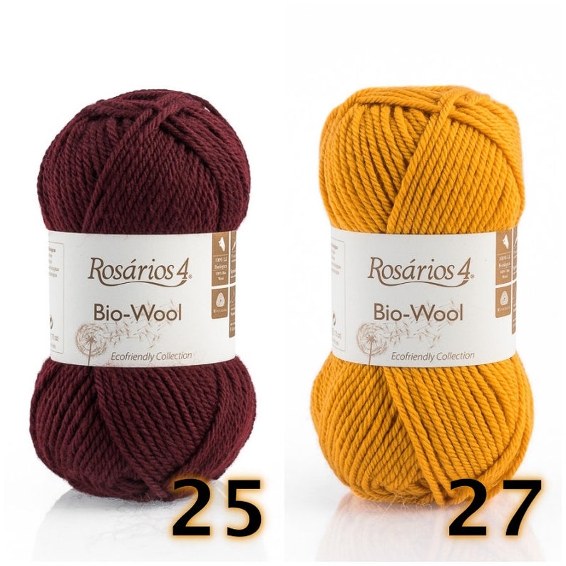 May include: Two skeins of Ros&aacute;rios 4 Bio-Wool yarn, one in deep burgundy and one in mustard yellow. Each skein features a white paper label with the brand name, product name, and a dandelion graphic. The numbers 25 and 27 are printed below.