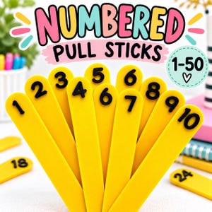 May include: A set of yellow sticks with raised black numbers from 1 to 10 arranged in a fan shape. The text "NUMBERED PULL STICKS" and "1-50" with a heart symbol are visible at the top. Additional yellow sticks with numbers 18 and 24 are visible.