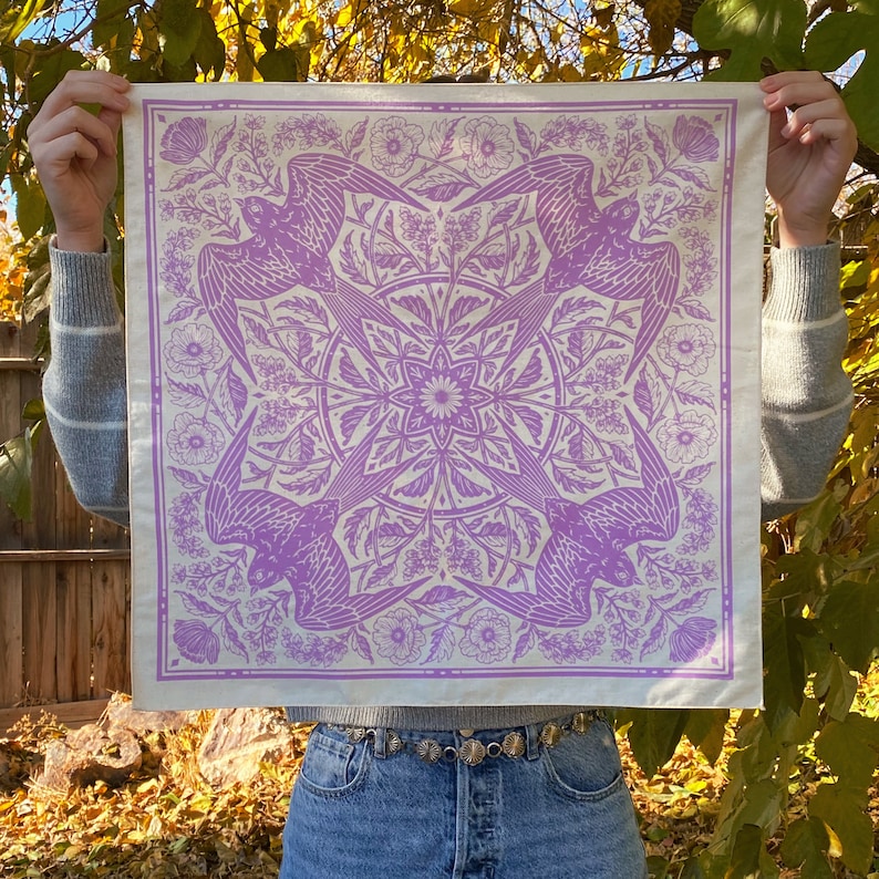 May include: A white bandana with a purple floral and bird design. The bandana features a repeating pattern of birds, flowers, and leaves.