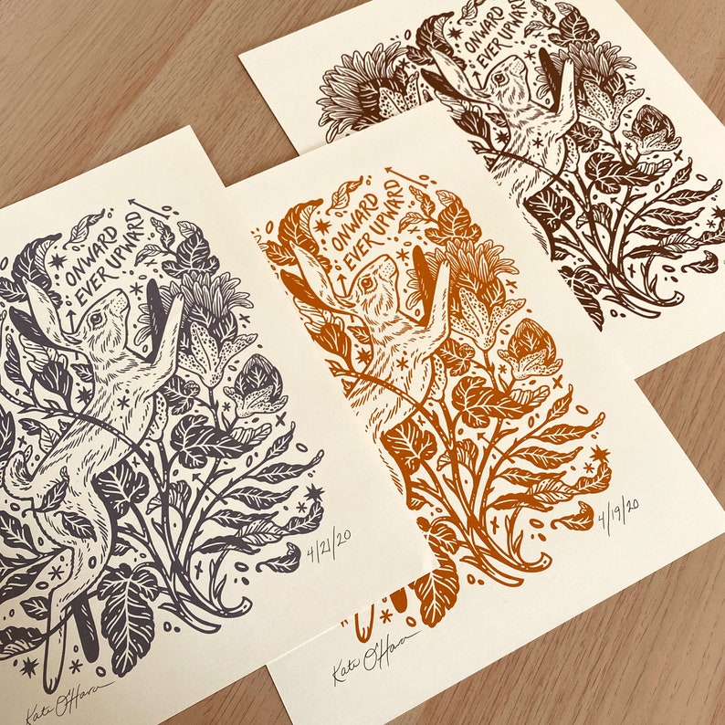 Pu&ograve; includere: Tre stampe di un'illustrazione in bianco e nero di due lepri che saltano attraverso un campo di fiori. Il testo "ONWARD EVER UPWARD" &egrave; scritto in un cerchio attorno alle lepri. Le stampe sono datate 4/19/20 e 4/21/20. Il nome dell'artista, "Kate Offan", &egrave; scritto in fondo a ciascuna stampa.