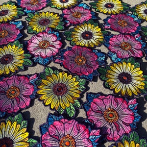 May include: A collection of colorful embroidered flower patches. The patches feature a variety of flowers, including sunflowers, daisies, and roses. The patches are perfect for adding a touch of whimsy to clothing, bags, or other accessories.