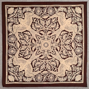 May include: A brown bandana with a tan design of four birds flying in a circle, surrounded by floral patterns. The birds are stylized and have a geometric look.