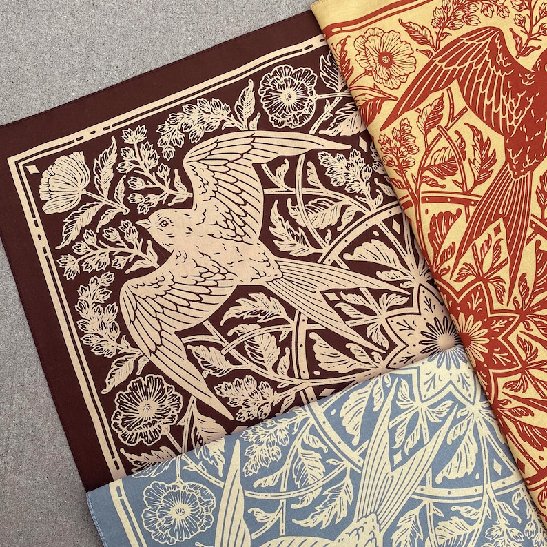 May include: Three fabric squares with a repeating pattern of stylized birds and floral designs. The squares are in shades of brown, red, and blue.