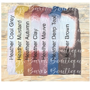 Puede incluir: Seis camisetas de diferentes colores con un diseño salpicado de lejía. Los colores son gris frío, mostaza, otoño, arcilla, malva, azul teal oscuro y marrón.