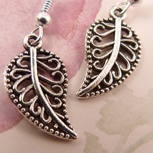 May include: A pair of silver earrings featuring a delicate leaf design. The leaves are crafted from intricate filigree work and have a slightly curved shape.
